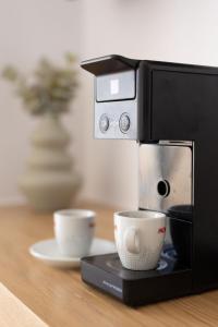 a coffee machine with a cup on a table at Panorama Suites in Kastraki Naxou