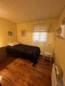 a bedroom with a bed and a chair in it at LITTLE SANDY-LIMIT 8 cottage in North Sebago