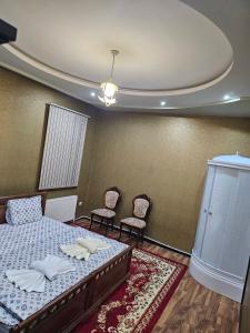 ein Schlafzimmer mit einem Bett und zwei Stühlen darin in der Unterkunft NL hotel in Yakkasaray