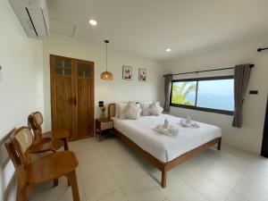 sypialnia z łóżkiem i dużym oknem w obiekcie Phangan Utopia Resort w mieście Mae Haad