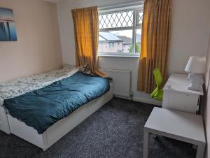een kleine slaapkamer met een bed en een raam bij Rooms close to City Centre in Beeston Hill