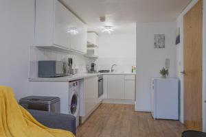 uma cozinha com armários brancos e um frigorífico em Beautiful Flat in Halifax - Perfect for Long Stays em Halifax