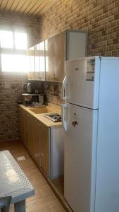 eine Küche mit einem weißen Kühlschrank im Zimmer in der Unterkunft فواصل الشمال للشقق المخدومة in Rafha