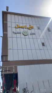 um edifício com um sinal na lateral em فواصل الشمال للشقق المخدومة em Rafha