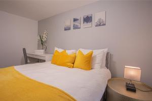 um quarto com uma cama com almofadas amarelas e uma secretária em Beautiful Flat in Halifax - Perfect for Long Stays em Halifax