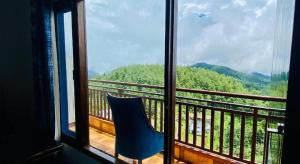 uma cadeira azul sentada numa varanda com vista para uma janela em Radiance valley Resort - A peaceful stay em Mai Jūbar