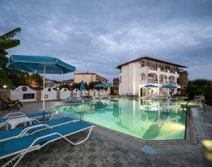 a large swimming pool with chairs and umbrellas at Estia hotel in Fourka