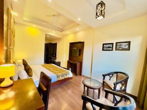 Mai JūbarにあるRadiance valley Resort - A peaceful stayのベッド、テーブル、椅子が備わるホテルルームです。