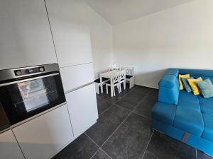 a kitchen with a blue couch and a table at Seaside Cottage Barbariga in Peroj +39 photos