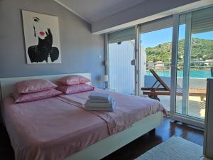 a bedroom with a bed with pink pillows and a balcony at Villa Stegic in Tisno +86 photos