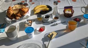 una mesa con pan, fruta y bebidas. en Alix au pays des Pierres Dorées, en Alix
