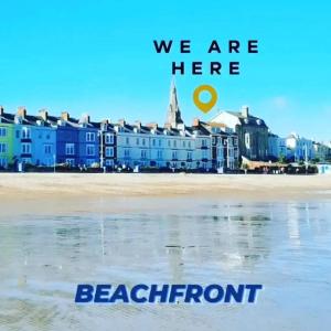 una vista de la playa con las palabras que estamos aquí frente a la playa en Penn House Hotel en Weymouth