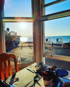una mesa con vistas al océano desde una ventana en Penn House Hotel en Weymouth