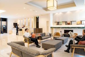 a group of people sitting in chairs in a lobby at Richmond Hotel Akita Ekimae in Akita
