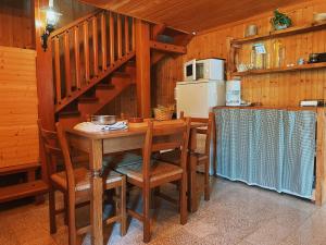 una cocina con una mesa de madera con sillas y una escalera en Casa Maitö, en Senarega