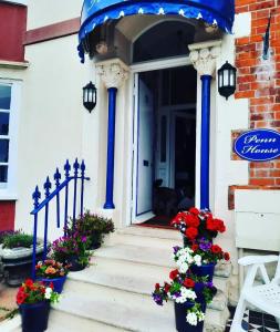 una casa con columnas azules y flores en las escaleras en Penn House Hotel en Weymouth