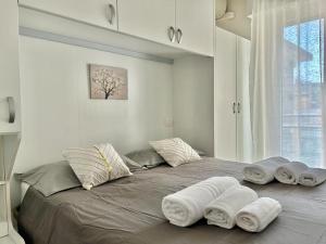 a large bed with towels on it in a room at Nino Bixio Flexrent - Abissinia in Riccione