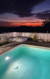 ein blauer Pool mit Sonnenuntergang im Hintergrund in der Unterkunft Villa Panorama sulle Egadi in Parrinello 
