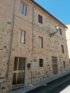 un edificio de ladrillo con puertas y ventanas. en La Casetta di Mimmi en Castel Viscardo