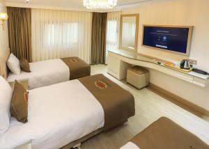 um quarto de hotel com duas camas e uma televisão de ecrã plano em Safa Hotel Old City em Istambul