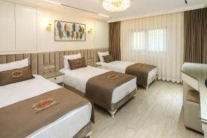 um quarto de hotel com três camas e um lustre em Safa Hotel Old City em Istambul