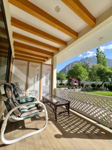 a porch with a chair and a coffee table at Hotel Travel Lodge in Skardu