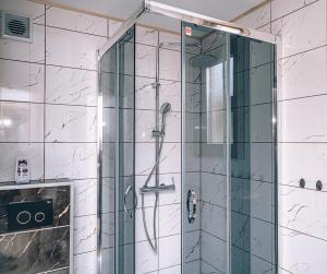 y baño con ducha y puerta de cristal. en Górskie Chatki Krysi i Piotrka Bursztynowy, en Stronie Śląskie
