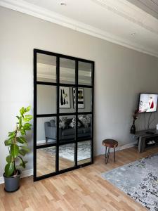 einen Spiegel im Wohnzimmer mit Sofa in der Unterkunft Ekhaya in Kimberley