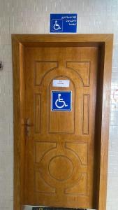 una porta di legno con un cartello per disabili di فواصل الشمال للشقق المخدومة a Rafha