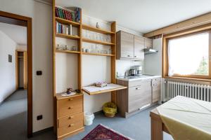 una pequeña cocina con armarios de madera y una ventana en Haus Widdersteinblick en Riezlern