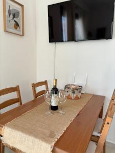una mesa de madera con dos copas de vino. en Anemar Lefkada, en Drymon