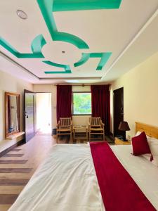 a large bedroom with a large bed with a red blanket at Hotel Travel Lodge in Skardu