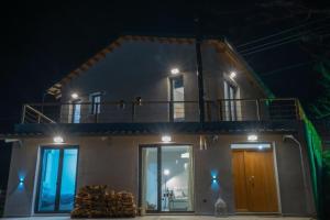 a house with a balcony on top of it at night at Balou lodge in Orma
