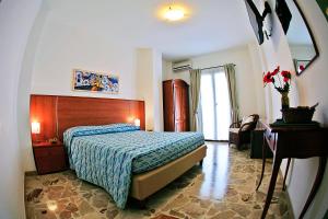 a bedroom with a bed and a chair and a window at B&B La Veduta in Scilla