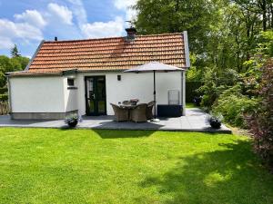 een klein wit huis met een paraplu in een tuin bij De Egelburcht in Garderen