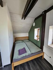 a small bed in a room with a green wall at Apartmán YASNE in Ostrava