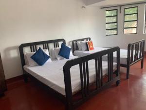 2 letti in una camera con cuscini bianchi e blu di Kandy Siebel Bungalow a Kandy