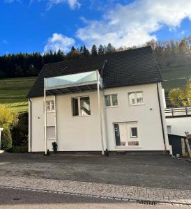 ein weißes Haus mit Glasdach in der Unterkunft Ferienwohnung Schwarzwaldliebe in Bad Peterstal-Griesbach