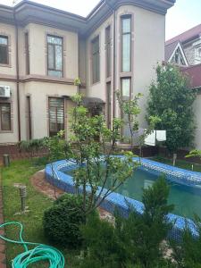 ein Haus mit einem Pool vor einem Haus in der Unterkunft NL hotel in Yakkasaray