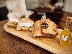 een houten snijplank met brood en een fles mosterd bij The Loft Luxury Room Suite con minipiscina in Adelfia