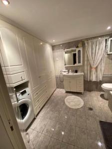 een badkamer met een wasmachine en een wastafel bij Lori House in Corfu. Feel like your home in Skriperón