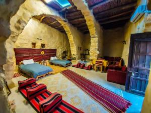 a large room with two beds and a stone wall at bit mumia house & restaurant in Kerak