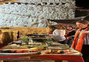 una mesa llena de comida con gente a su alrededor en bit mumia house & restaurant, en Kerak