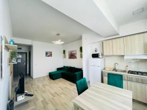 a kitchen and living room with a table and a couch at Summerland Studios Nuba in Mamaia