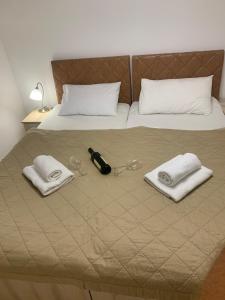 a bed with two glasses and towels on it at Jagodina Wing Apartman 2 in Jagodina