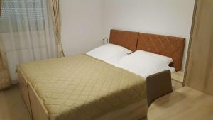 a bed in a small room with a window at Jagodina Wing Apartman 2 in Jagodina