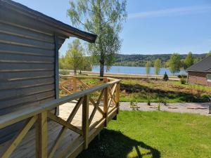 een houten terras naast een gebouw met uitzicht op een meer bij Villaberg in Arvika