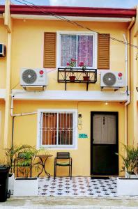 a yellow house with two windows and a door at Charming Duplex Apartment in Tagbilaran City