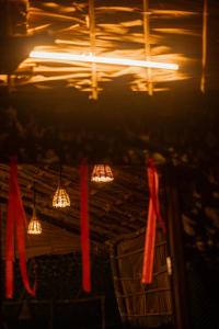 eine Gruppe von Lichtern, die an einer Decke mit rotem Band hängen in der Unterkunft Wonderwoods Tent Camping Munnar in Munnar