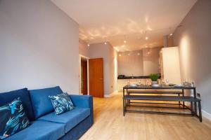 a living room with a blue couch and a table at The Diamond Suite in Manchester